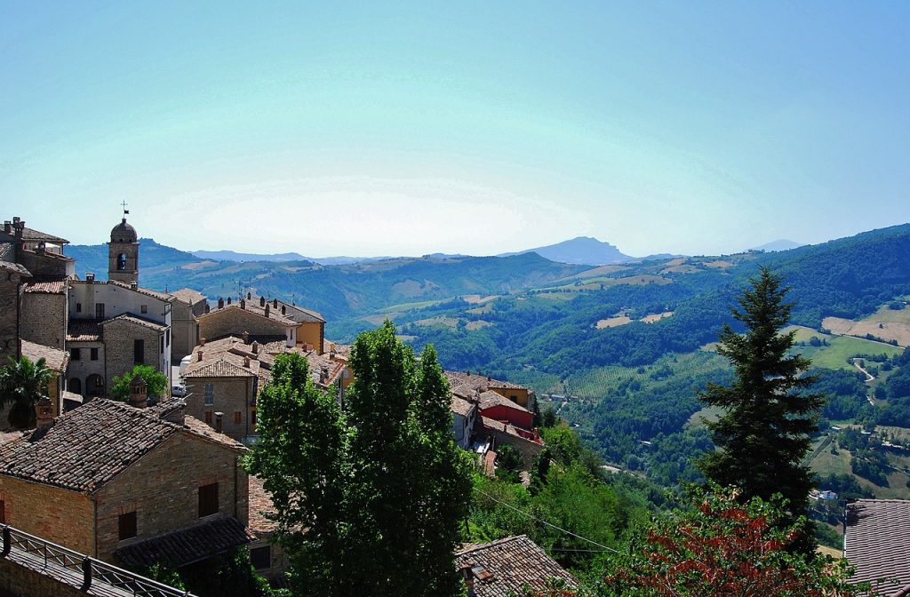 Panoramic view of Monte San Martino, featuring rolling hills and greenery, captured by Paula Castelli in 2017.